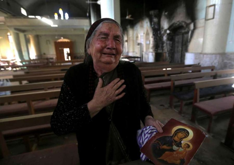 A Christian Woman cries after she sees her church destroyed. 