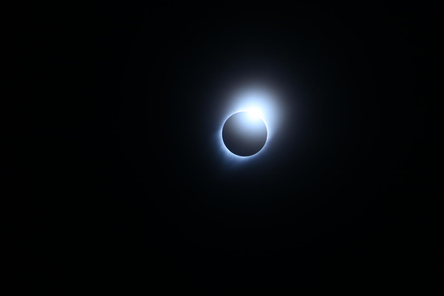 The sun begins to peek out as the moon reaches totality. 