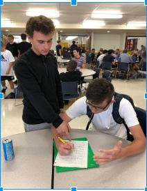 Grant Siebert (21) receives help with his homework.