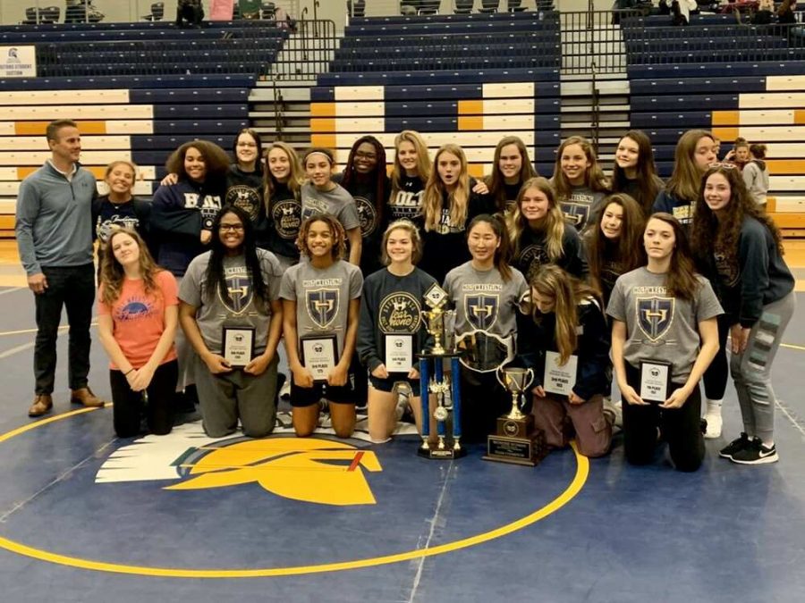 Holts girls wrestling team poses with their new hardware that they proudly bring home. 