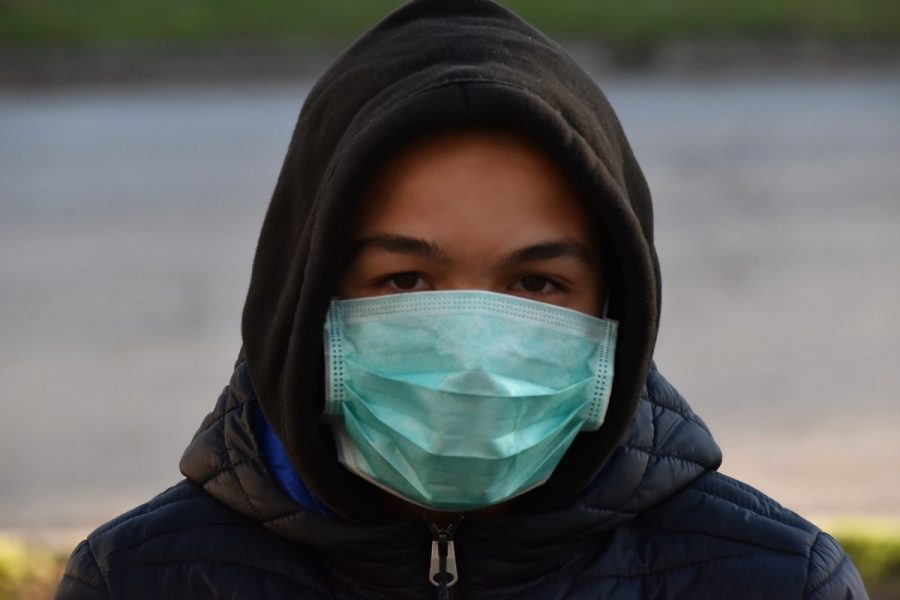 A kid having to go out with a mask in public in order to stay safe.