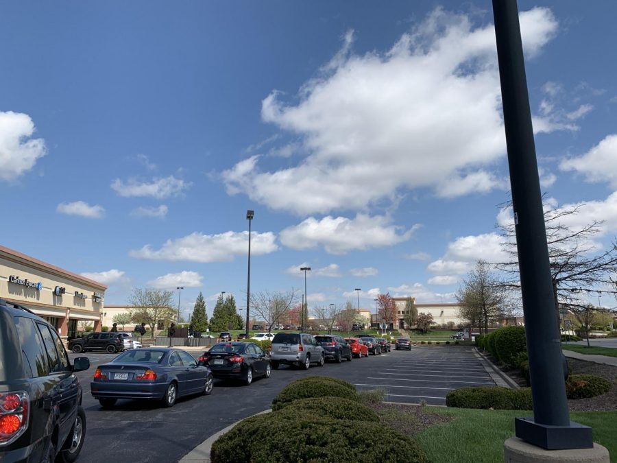 A line full of cars at Starbucks wraps around the building.
