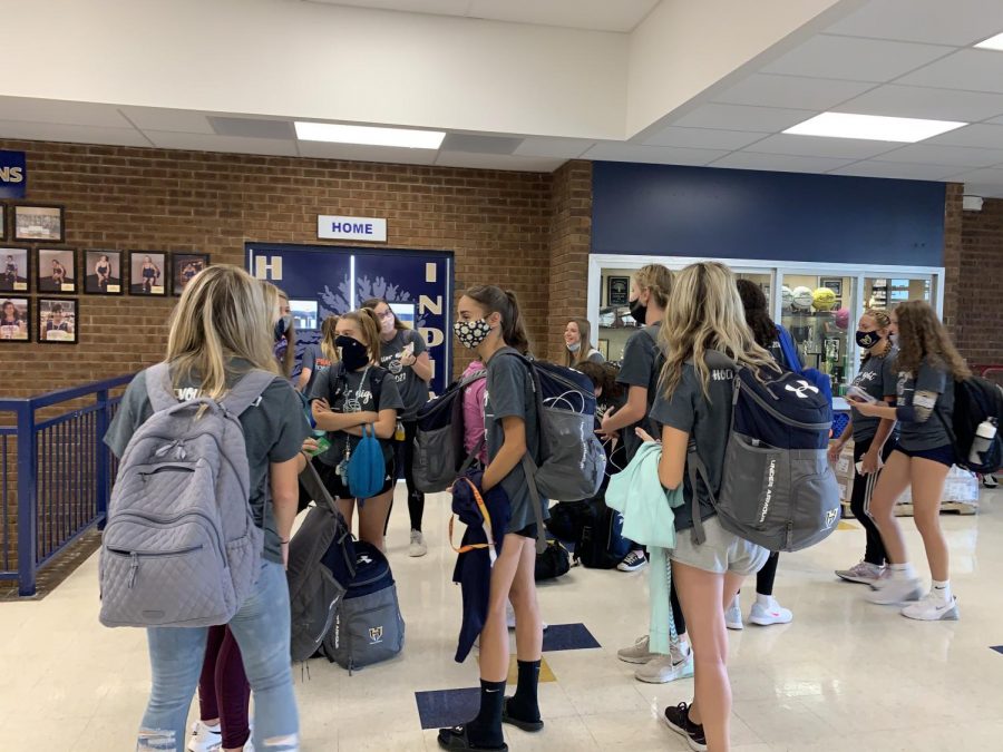 As the volleyball teams wait for their bus to take them to Francis Howell High School for an away game, they keep each other safe by wearing their masks.