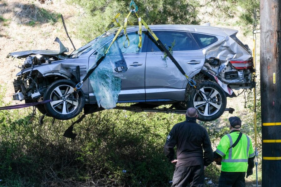 A crane is being used to lift up the SUV from a rollover accident in which belongs to Tiger Woods.