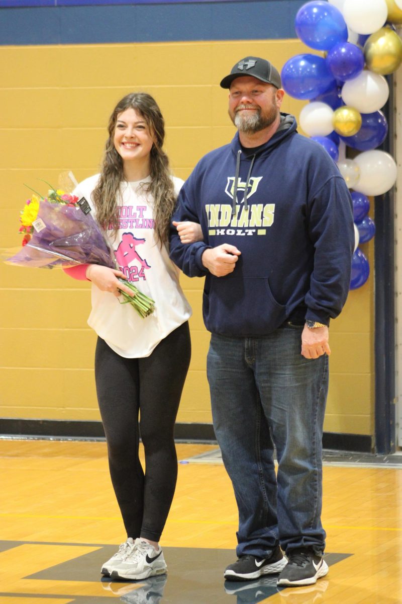 Manager Mera Manning (24) walks out with her dad celebrating her senior year.